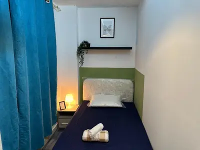 a small bedroom with a bed with a blue blanket at Enchanted Stay Partition Room in Barsha Heights in Tecom in Dubai