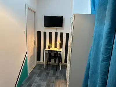 a small room with a table and a tv on a wall at Enchanted Stay Partition Room in Barsha Heights in Tecom in Dubai