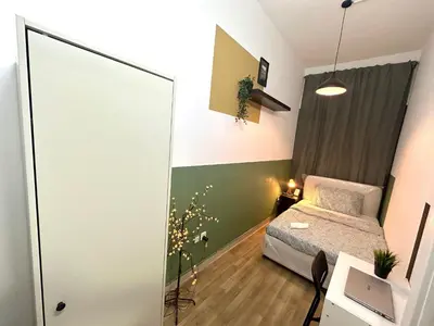 a small room with a bed and a glass wall at Passion Nest Room in Barsha Heights Tecom in Dubai