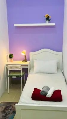 a bedroom with a white bed with a desk and a chair at Solo Haven Room in Barsha Heights Tecom in Dubai