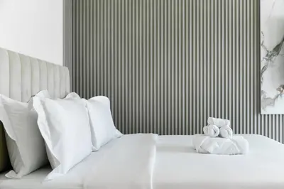 a white bed with white pillows and a teddy bear on it at Luxury Oasis | Private Beach & Infinity Pool in Dubai
