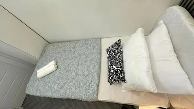 a bed with white pillows and a tie on it at Best Solo Room in Barsha heights Tecom in Dubai