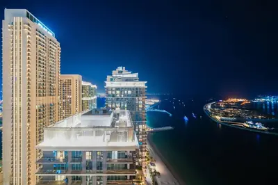 a view of a city skyline at night at Ultra Luxury Apt | Private Beach + Infinity Pool in Dubai