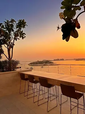 a table on a balcony with a view of the ocean at Ultra Luxury Apt | Private Beach + Infinity Pool in Dubai