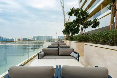 a row of chaise lounge chairs on a building balcony at Ultra Luxury Apt | Private Beach + Infinity Pool in Dubai