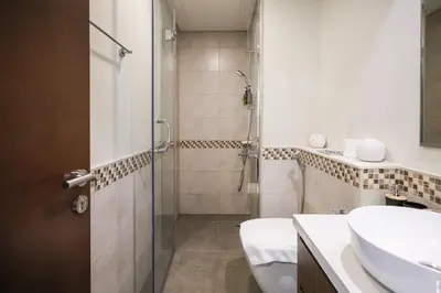 a bathroom with a shower and a sink and a toilet at Comfy 1BR with Large Balcony - 15-min to Mall & Burj in Dubai