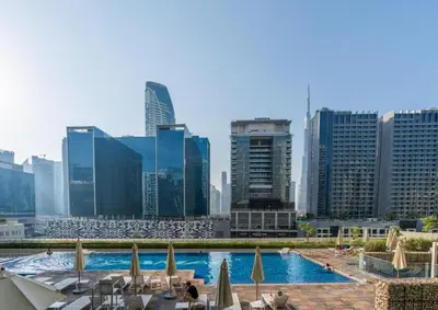 a view of a pool in a city with buildings at Comfy 1BR with Large Balcony - 15-min to Mall & Burj in Dubai