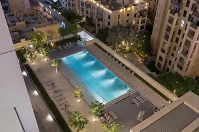 an overhead view of a swimming pool in a city at night at 2BR Burj Khalifa Dubai Mall View in Dubai