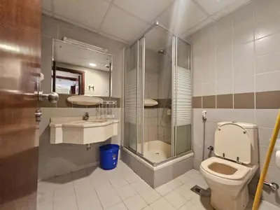 a bathroom with a toilet and a shower and a sink at Cricket Tower in Dubai