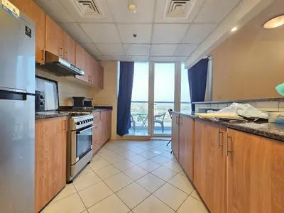 a kitchen with wooden cabinets and a view of the ocean at Cricket Tower in Dubai