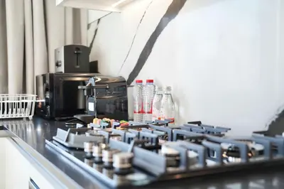 a kitchen counter with a stove top with bottles on it at Spacious 1BR Balcony Jacuzzi in Dubai