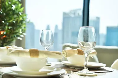 a table with two wine glasses and napkins on it at Spacious 1BR Balcony Jacuzzi in Dubai
