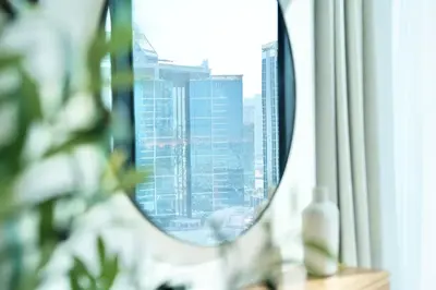 a mirror in a window with a view of a city at Spacious 1BR Balcony Jacuzzi in Dubai