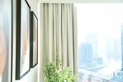 a window in a room with a view of a city at Spacious 1BR Balcony Jacuzzi in Dubai