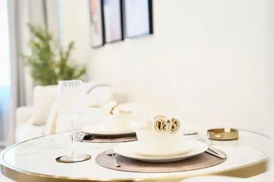 a table with plates and cups and a wine glass at Jacuzzi Canal view BusinessBay in Dubai