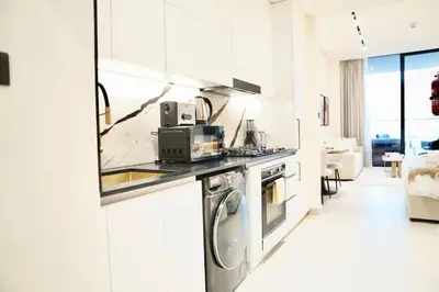 a white kitchen with a stove and a microwave at Canal View Studio Jacuzzi in Dubai