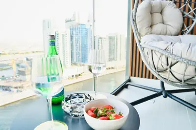 a table with a bowl of fruit and two wine glasses at Exclusive Jacuzzi Canal View in Dubai