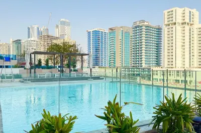 a large swimming pool in a city with tall buildings at Luxury Studio w Jacuzzi Balcony in Dubai