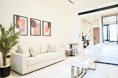 a white living room with a white couch and a table at Luxury Studio w Jacuzzi Balcony in Dubai