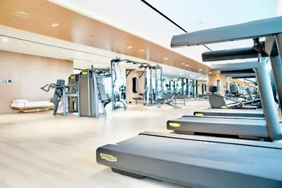 a gym with treadmills and machines in a room at Luxury Studio w Jacuzzi Balcony in Dubai