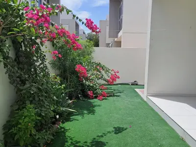 a garden with pink flowers on the side of a building at Damac hills 2 vardon cluster townhouse in Dubai
