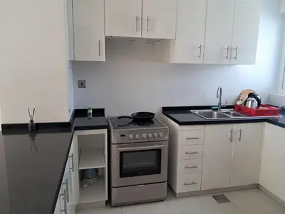 a small kitchen with a stove and a sink at Damac hills 2 vardon cluster townhouse in Dubai