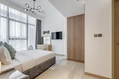 a bedroom with a large bed and a chandelier at GLOBALSTAY Elegant Meydan Apartments - Azizi Riviera 40 in Dubai