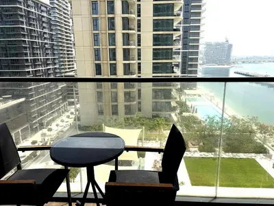 a balcony with a table and chairs in a building at Palm View Marina Vista 1BR Beachfront in Dubai