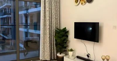 a living room with a flat screen tv on a wall at Laya Heights Residence by Hogar in Dubai