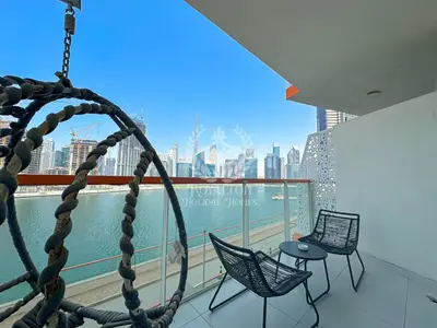 a balcony with two chairs and a view of the city at Royalton - Cozy Studio with Burj Khalifa & Canal Views in Dubai