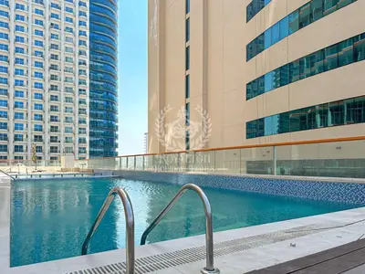 a swimming pool in a city with tall buildings at Royalton - Cozy Studio with Burj Khalifa & Canal Views in Dubai