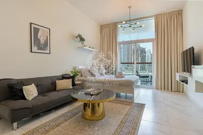 a living room with a couch and a table at Royalton - Cozy Studio with Burj Khalifa & Canal Views in Dubai