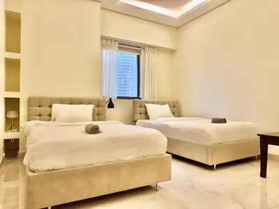 a bedroom with two beds and a couch at Renovated 2bdr in Sadaf 7 JBR in Dubai