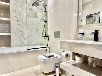 a bathroom with a toilet and a shower and a sink at Renovated 2bdr in Sadaf 7 JBR in Dubai