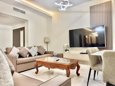 a living room with a couch and a tv at Renovated 2bdr in Sadaf 7 JBR in Dubai
