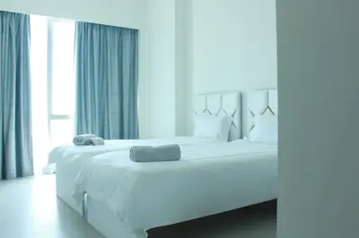a white bed in a room with a large window at Next to Burj Khalifa 5 Mins Walk To Dubai Mall in Dubai
