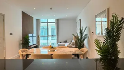 a living room with a table and chairs at DAYF-POLO Modern 1BR Escape Polo Residences Meydan in Dubai