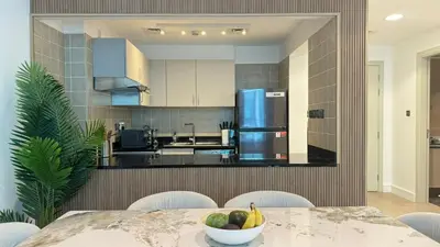 a kitchen with a table with a bowl of fruit on it at DAYF-POLO Modern 1BR Escape Polo Residences Meydan in Dubai