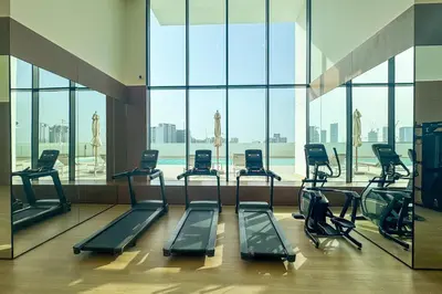 a gym with a bunch of treadmills in a building at Tranquil 1Bedroom in Binghatti Gardenia in Dubai