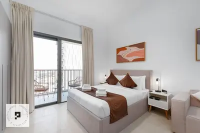 a bedroom with a large bed and a balcony at Affordable New Studio I MAG 980 I Summer Deal in Dubai