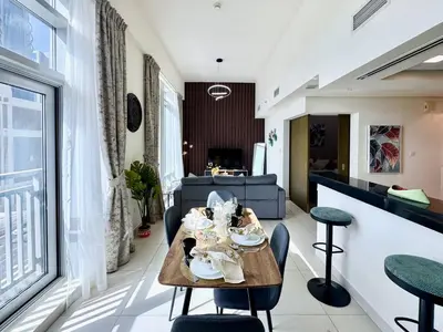 a dining room and living room with a table and chairs at Luxury Apt Near Burj & Metro in Dubai
