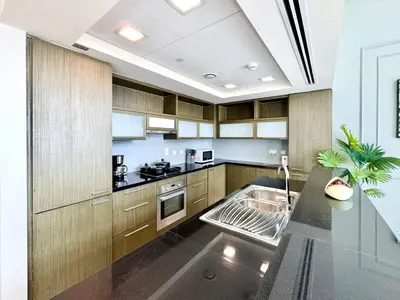 a kitchen with wooden cabinets and a stainless steel sink at Luxury Apt Near Burj & Metro in Dubai