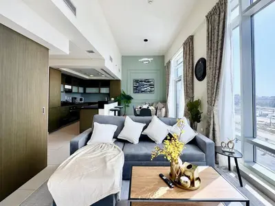 a living room with a blue couch and a table at Luxury Apt Near Burj & Metro in Dubai