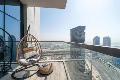 a balcony with a rattan chair on top of a building at Frank Porter - MADA Residences, Downtown in Dubai