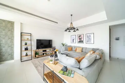 a living room with a couch and a tv at Frank Porter - MADA Residences, Downtown in Dubai