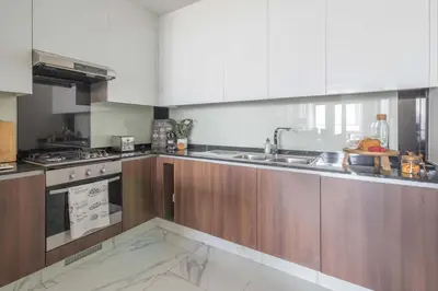 a kitchen with wooden cabinets and a sink and a stove at Frank Porter - J One Tower, Buisness Bay in Dubai
