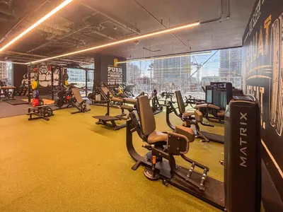 a gym with rows of treadmills and cardio machines at Frank Poretr - MBL Royal, Jumeirah Lakes Towers in Dubai