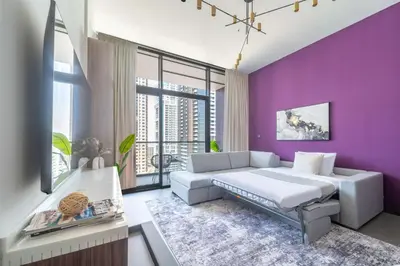 a bedroom with purple walls and a bed and a couch at Frank Poretr - MBL Royal, Jumeirah Lakes Towers in Dubai