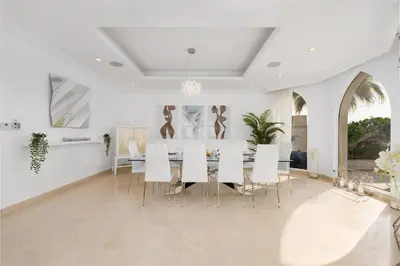 a dining room with a table and white chairs at Maison Privee - Ultra-Luxury Villa with Private Pool & Beach on Palm in Dubai