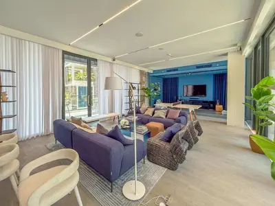 a living room with purple couches and a television at Frank Porter - Kensington Waters, Sobha Hartland in Dubai